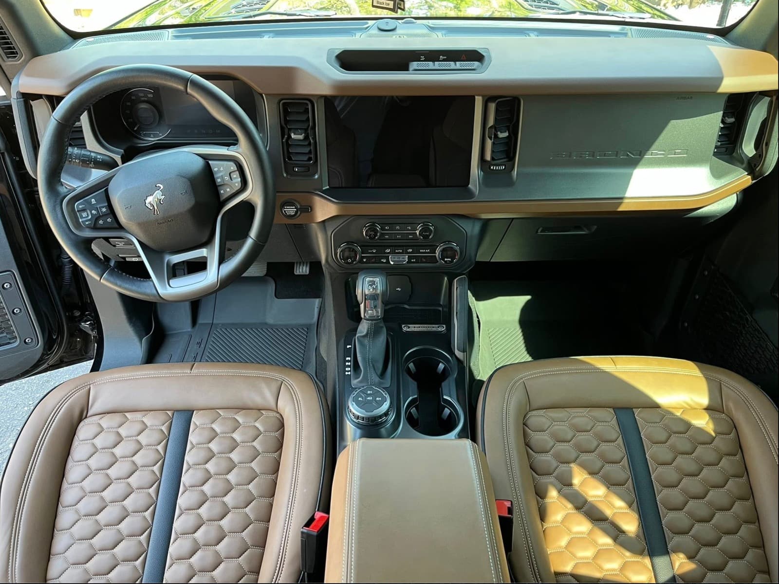 Ford Bronco cognac leather interior with clean dashboard, center console, and honeycomb seats.